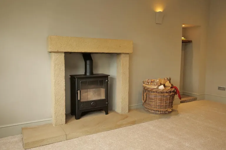 Decorated living room with a wood-burning stove and stone fireplace